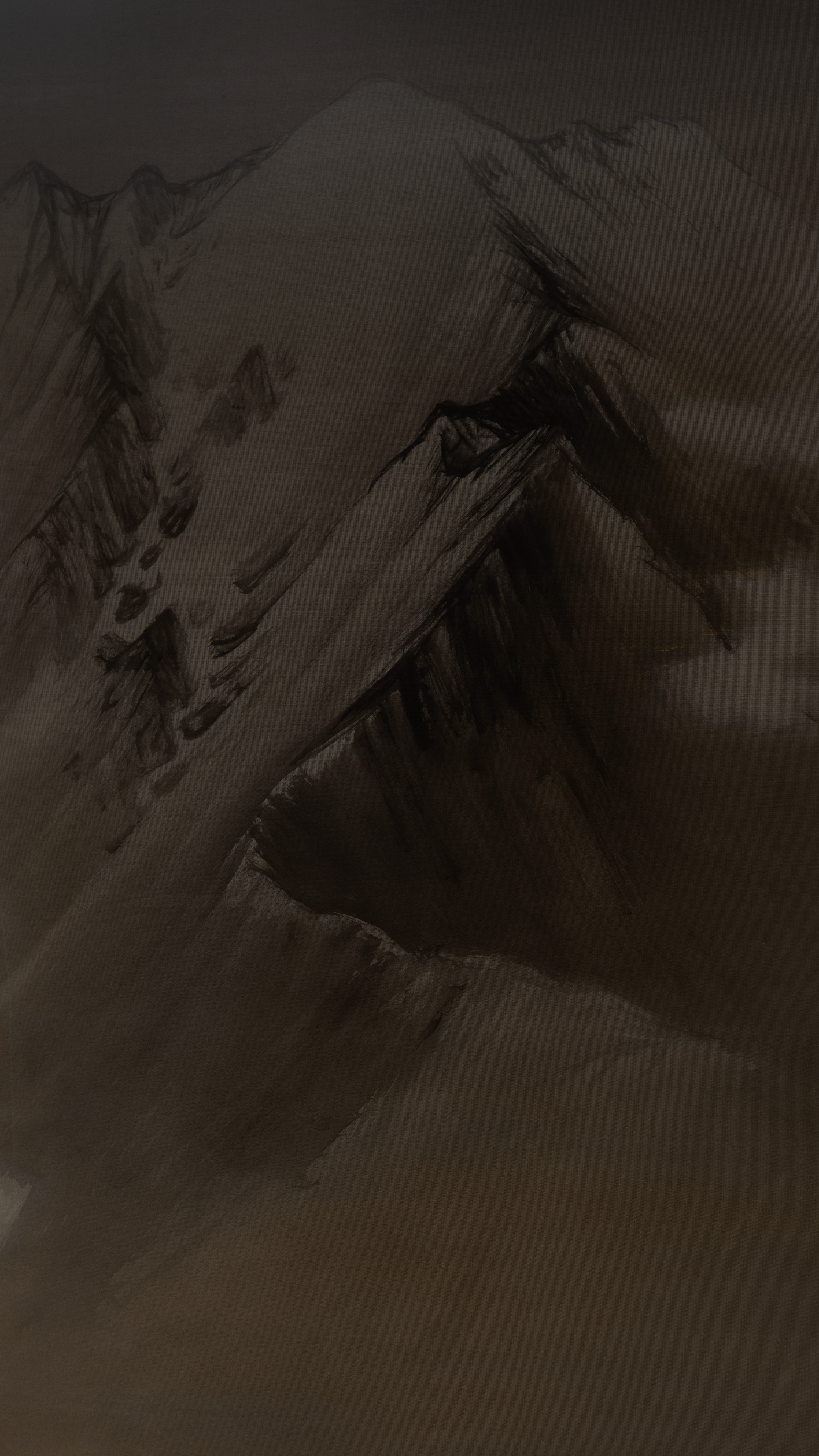 Dark moody vertical iPhone background from a Japanese painting: a snow-streaked mountain ridge in ink wash, pale slopes cut by black gullies and a thin dark treeline, a bare brown shoulder of rock across the foreground, everything sunk in warm shadow