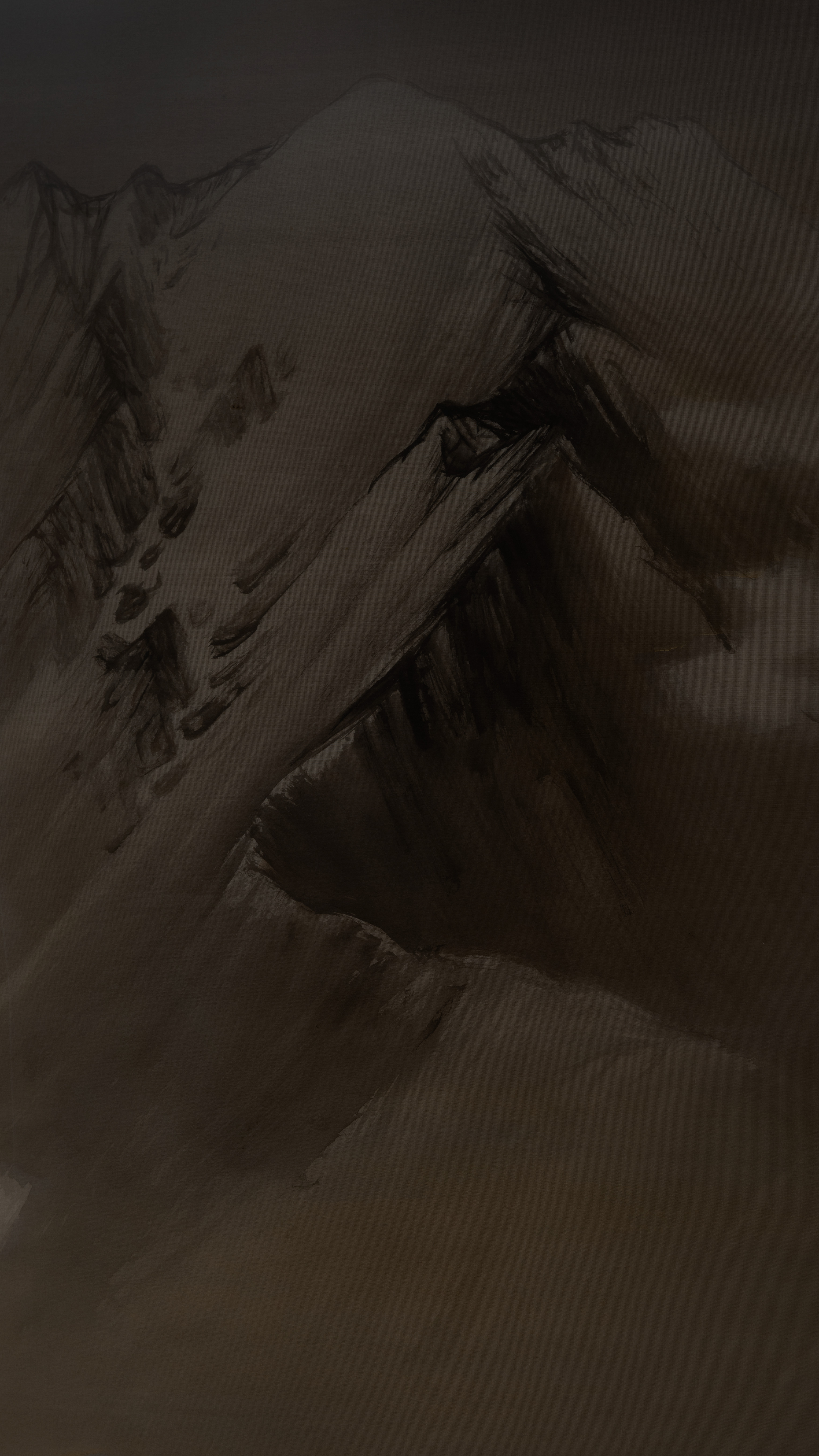 Dark moody vertical iPhone background from a Japanese painting: a snow-streaked mountain ridge in ink wash, pale slopes cut by black gullies and a thin dark treeline, a bare brown shoulder of rock across the foreground, everything sunk in warm shadow