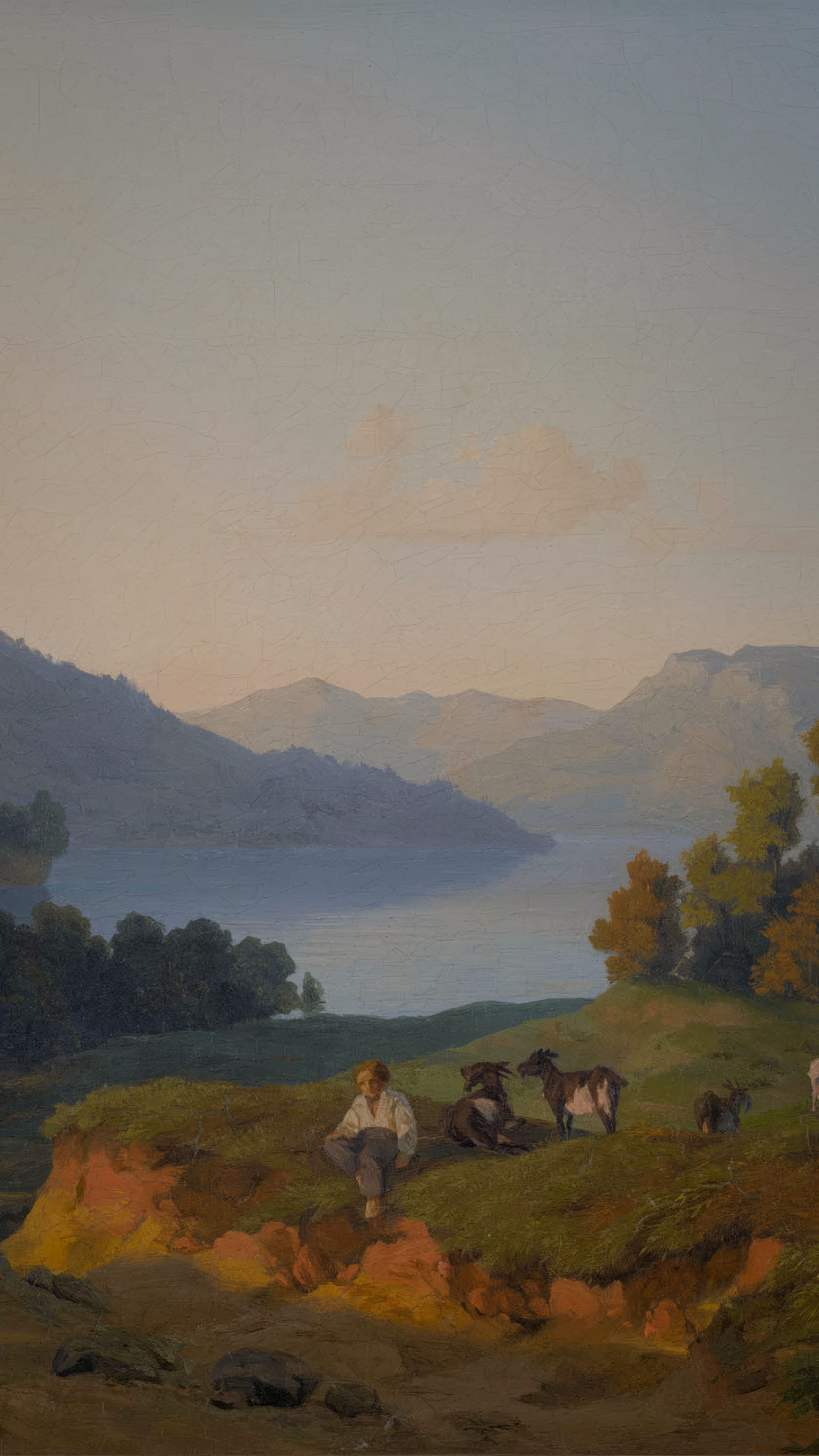 Vertical iPhone background from a painting: a pale evening sky over a long blue mountain lake, wooded ridges folding back into haze, and on the near bank a boy sitting in the grass beside two goats