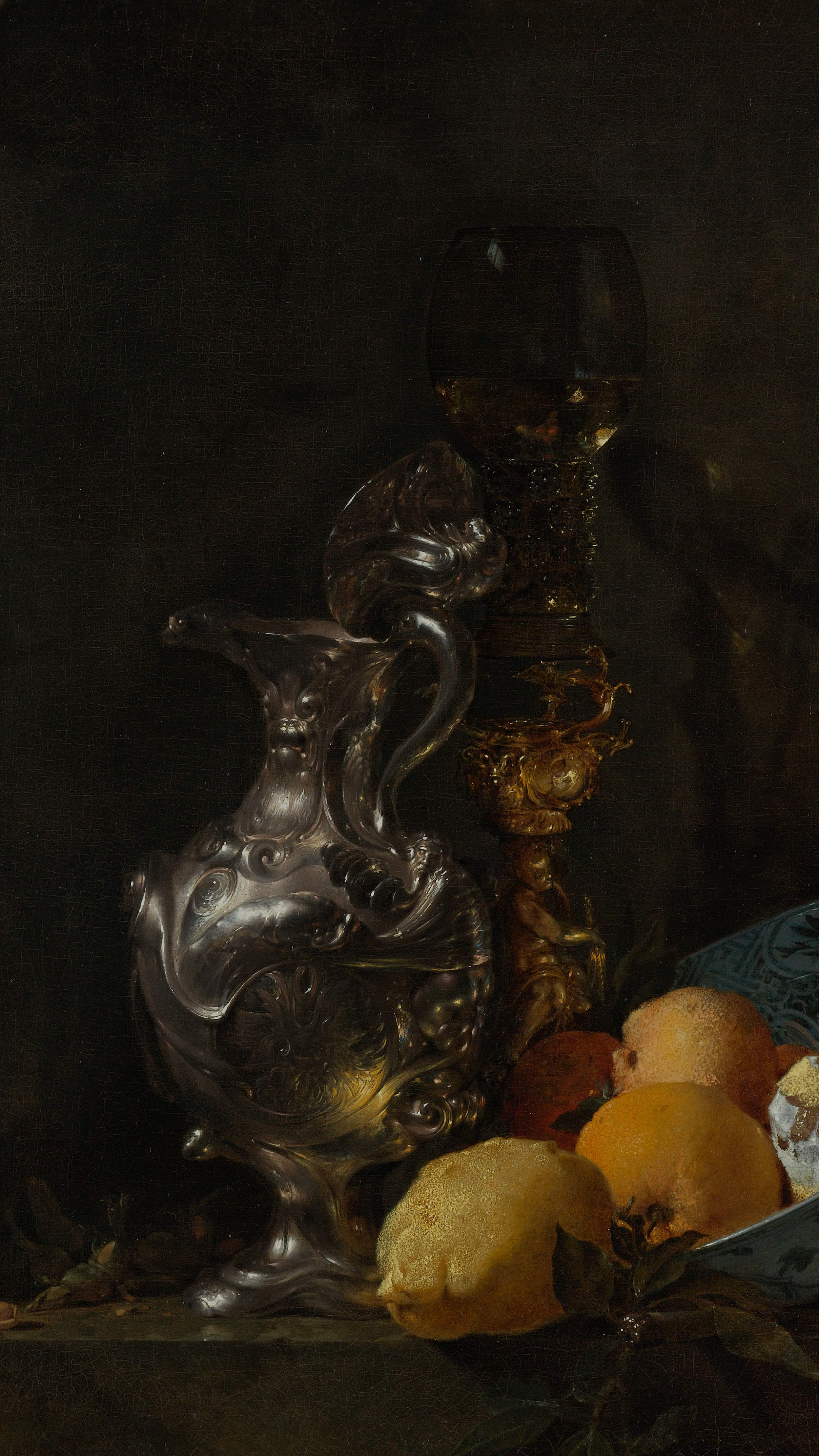 Dark academia vertical iPhone background from a painting: an ornate silver jug and a gold-stemmed wine glass beside a blue-and-white porcelain bowl of peaches and a lemon, set in a dark stone niche