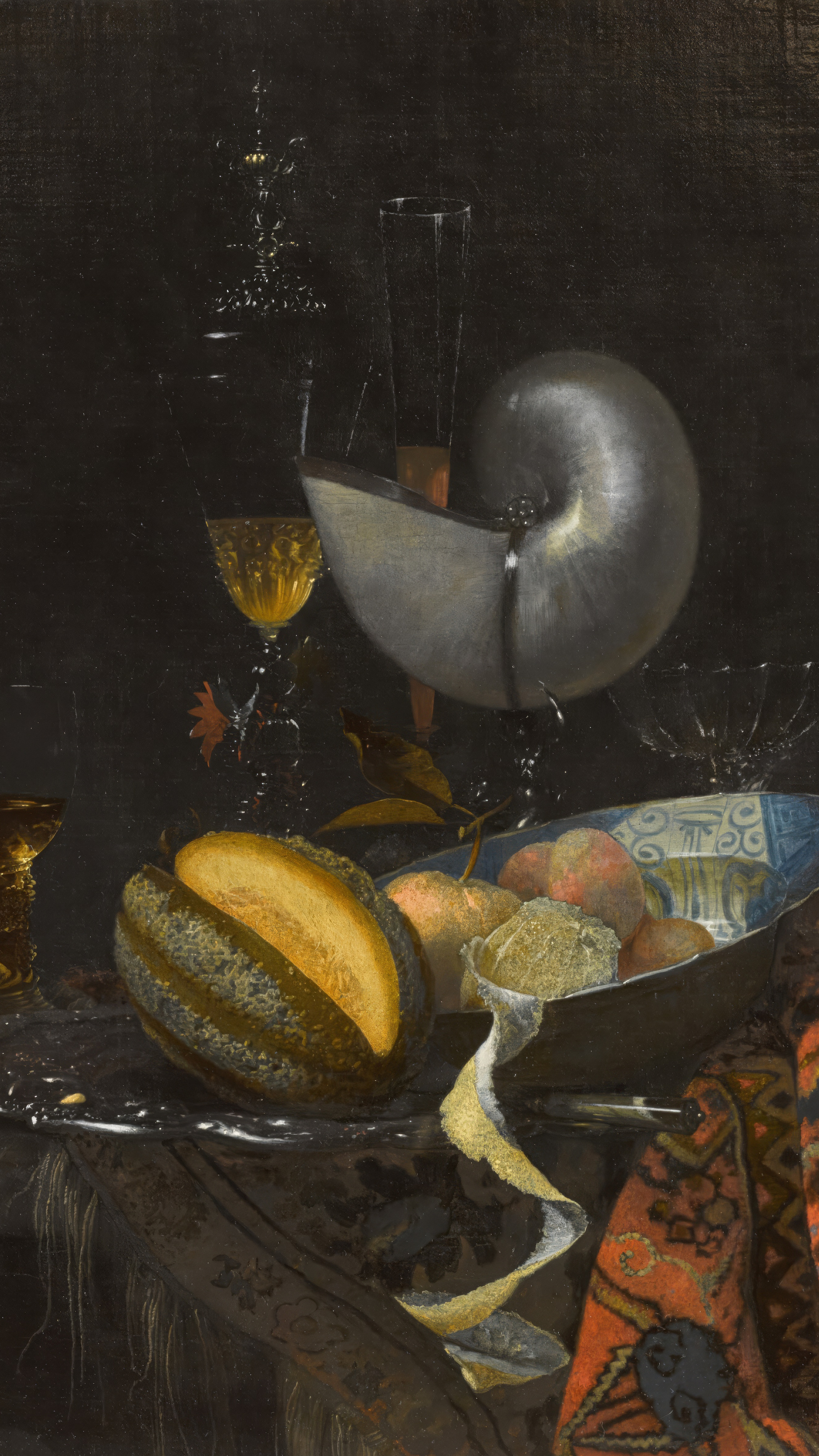 Dark academia vertical iPhone background from a painting: a silver-mounted nautilus cup tipped on its side beside wine glasses and a cut melon, a blue-and-white porcelain bowl of peaches on a dark cloth