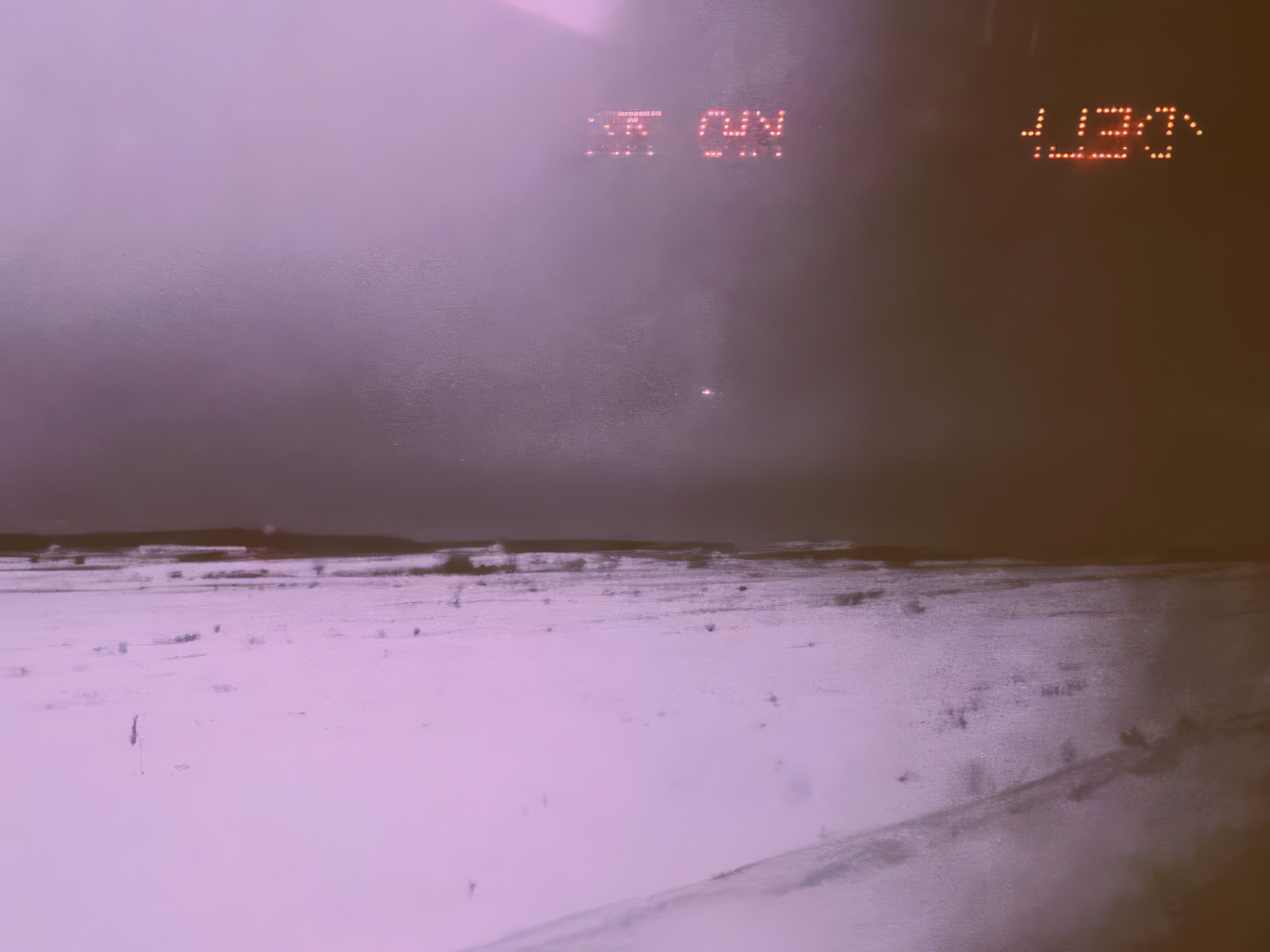 Desktop wallpaper photo: a beach at dusk in pink haze, seen through a windshield