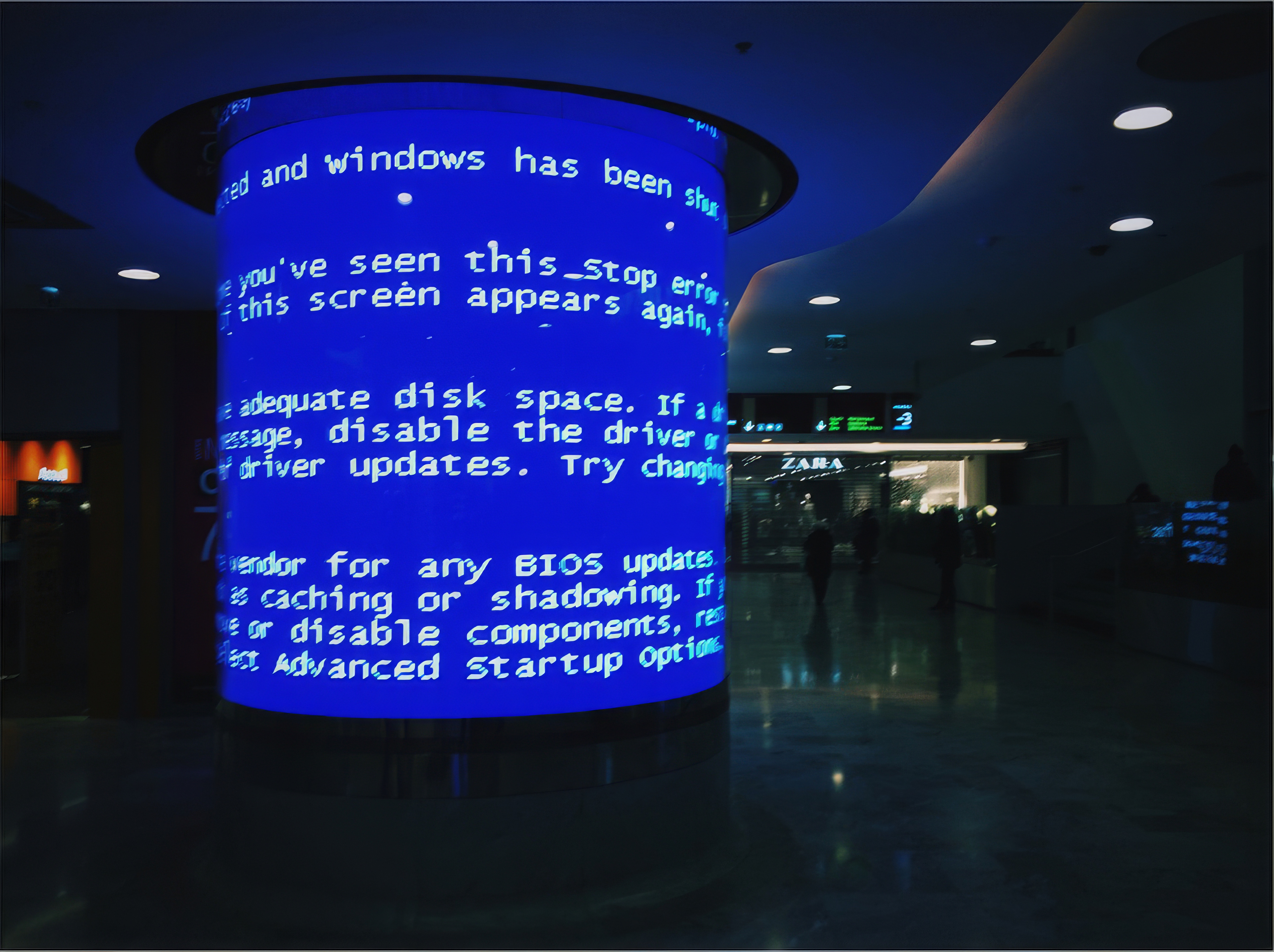 Desktop wallpaper photo: a crashed blue-screen error on a public terminal in an airport