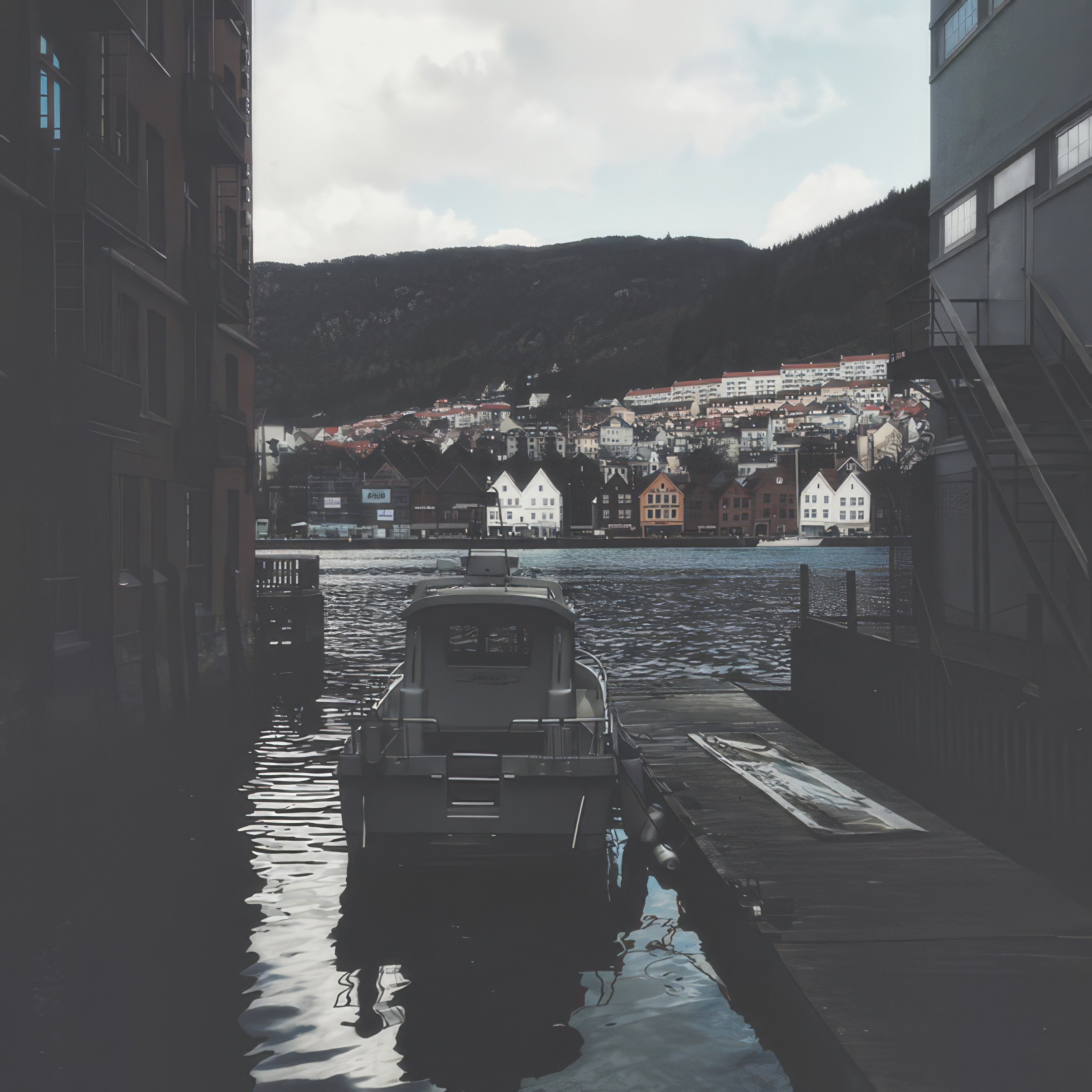 Phone wallpaper photo: small boats moored in a foggy harbour town, hills fading into mist