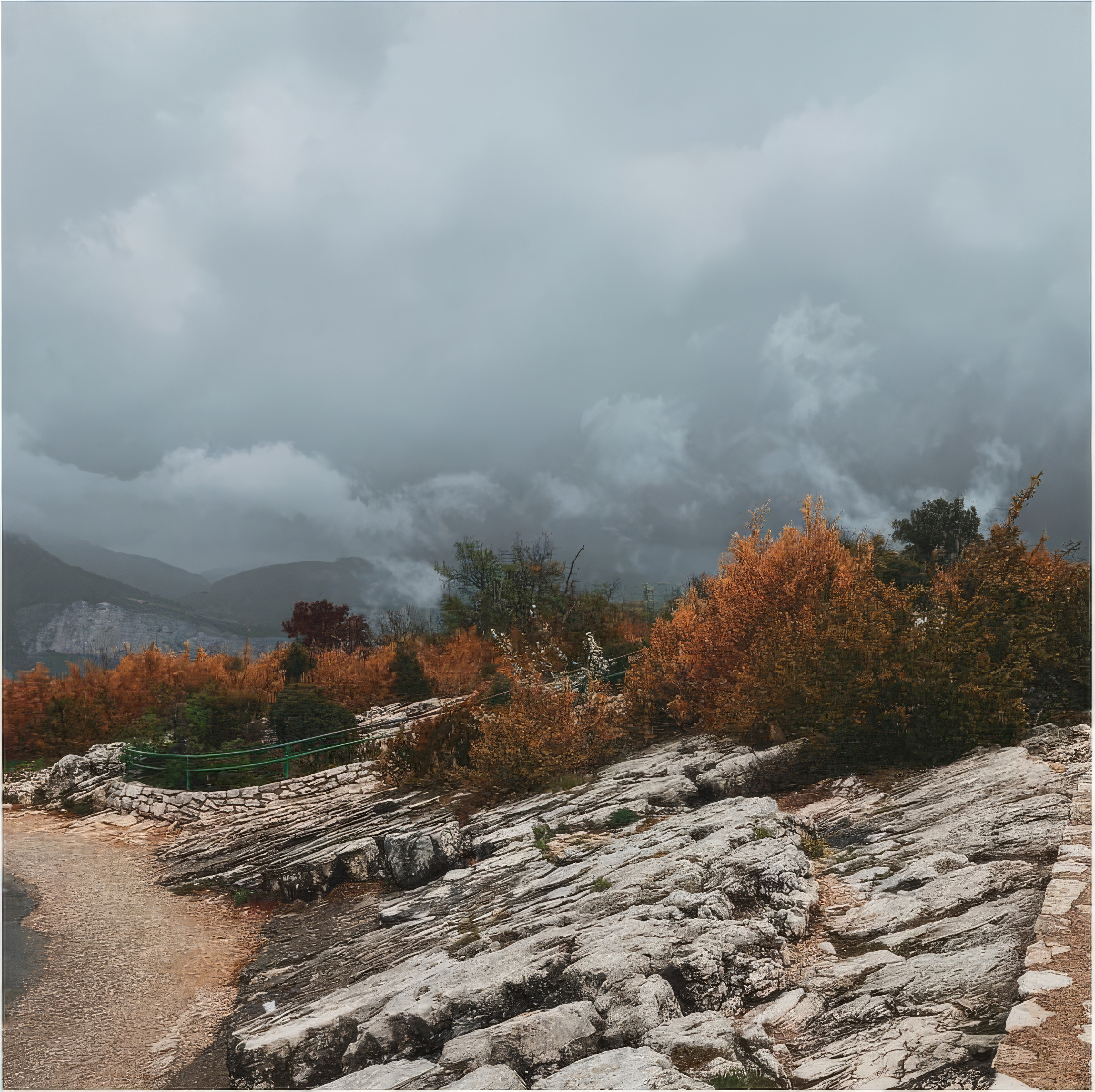 Phone wallpaper photo: heavy storm clouds rolling over hills above a rocky coastline path
